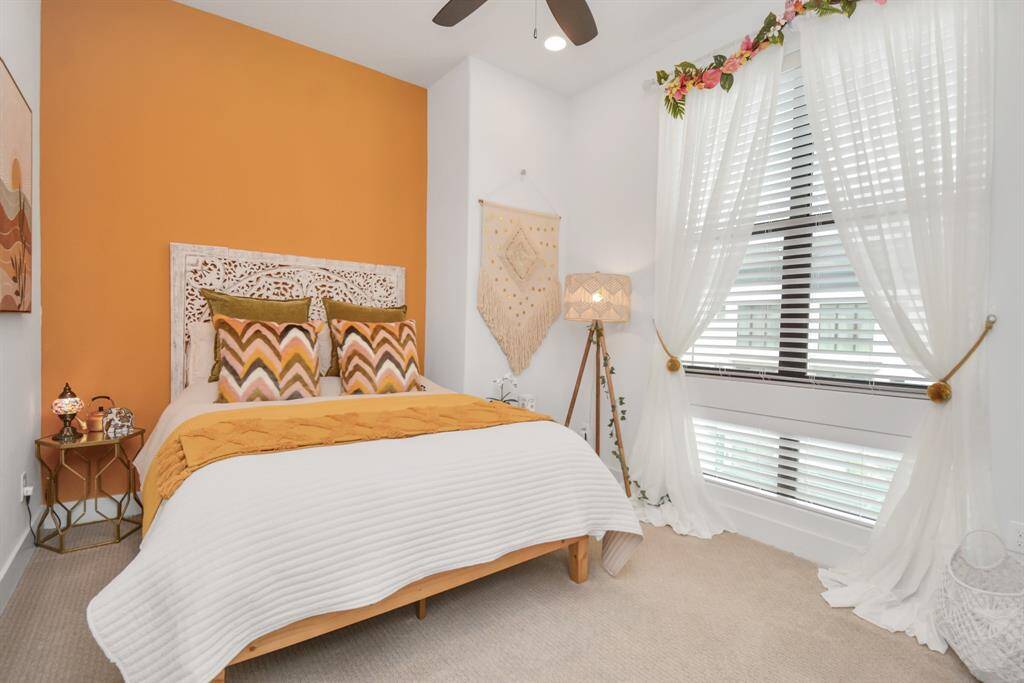 Bright third-floor bedroom featuring expansive windows for abundant natural light.