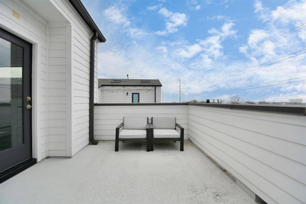 Charming rooftop patio with cozy seating and stunning Houston skyline views—a perfect spot to unwind!