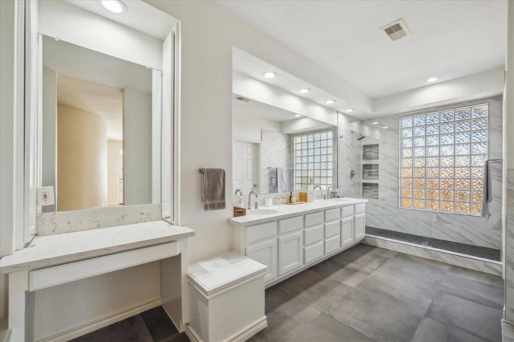 PRIMARY BATHROOM HAS BEEN RENOVATED WITH EXPANSIVE SHOWER, DUAL SINKS, UPGRADED LIGHTING AND MORE.