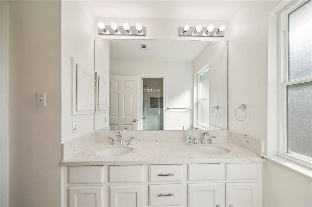 SECONDARY BATHROOM HAS BEEN UPGRADED WITH GRANITE COUNTERS AND DUAL SINKS.
