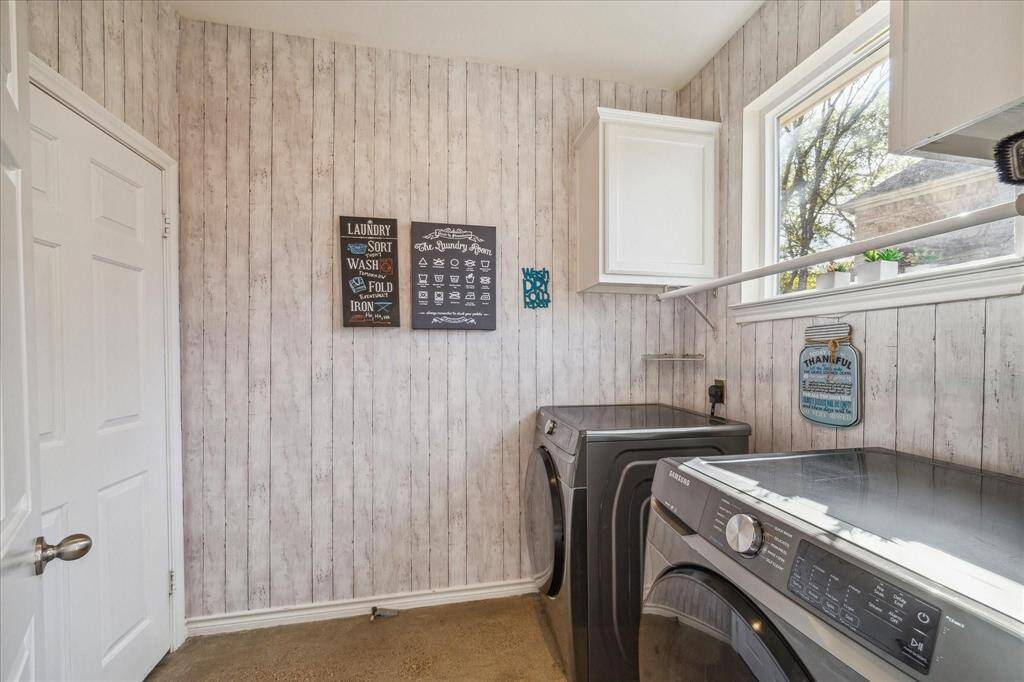 LAUNDRY IS LOADS OF FUN IN THIS SPACIOUS ROOM WITH HANGING RAIL AND CABINET STORAGE.