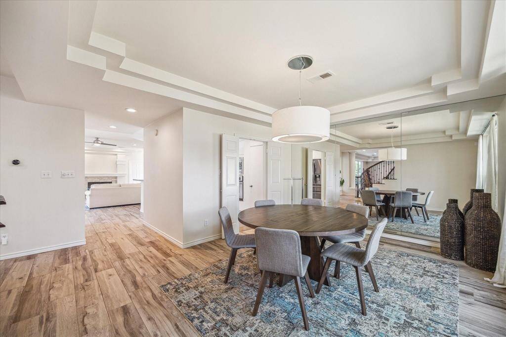 GRAND FORMAL DINING FEATURES A MODERN CHANDELIER, DOUBLE-TRAY CEILING, AND PLENTY OF SPACE FOR LARGE DINING TABLE.