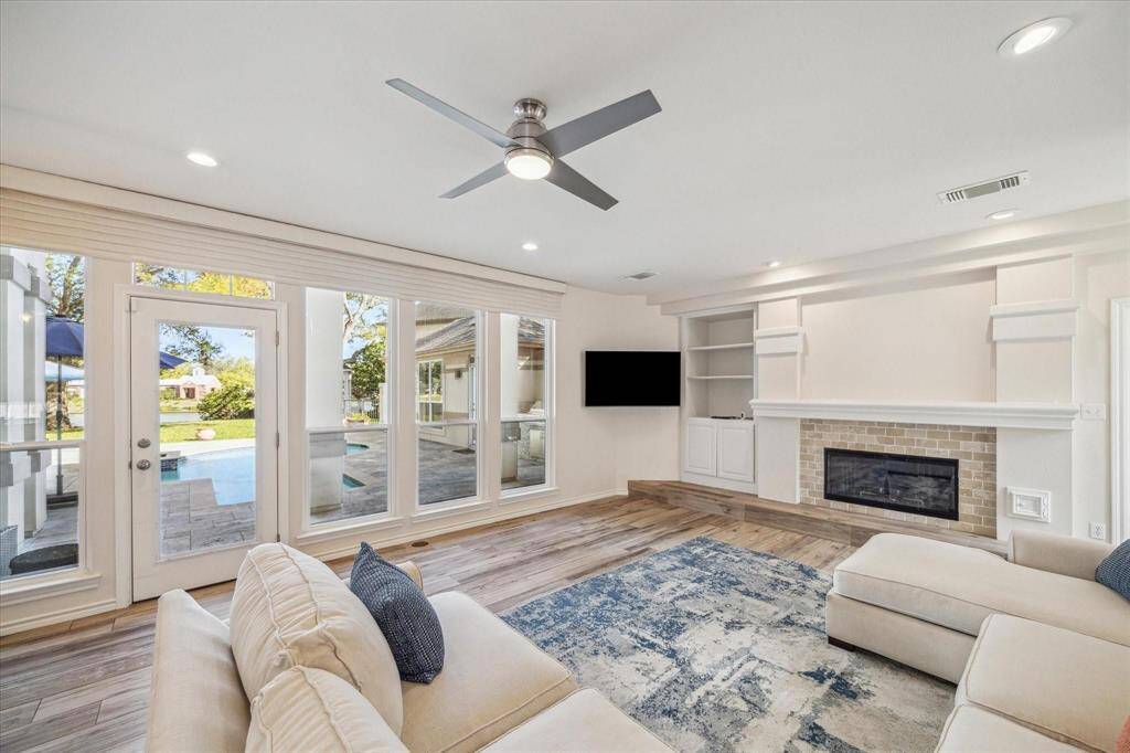 THE WOOD-LOOK TILE FLOORING CONTINUES THROUGHOUT THE FAMILY ROOM, CREATING A COHESIVE AESTHETIC. THE FIREPLACE HEARTH HAS BEEN UPGRADED WITH NEUTRAL TILE SURROUND.