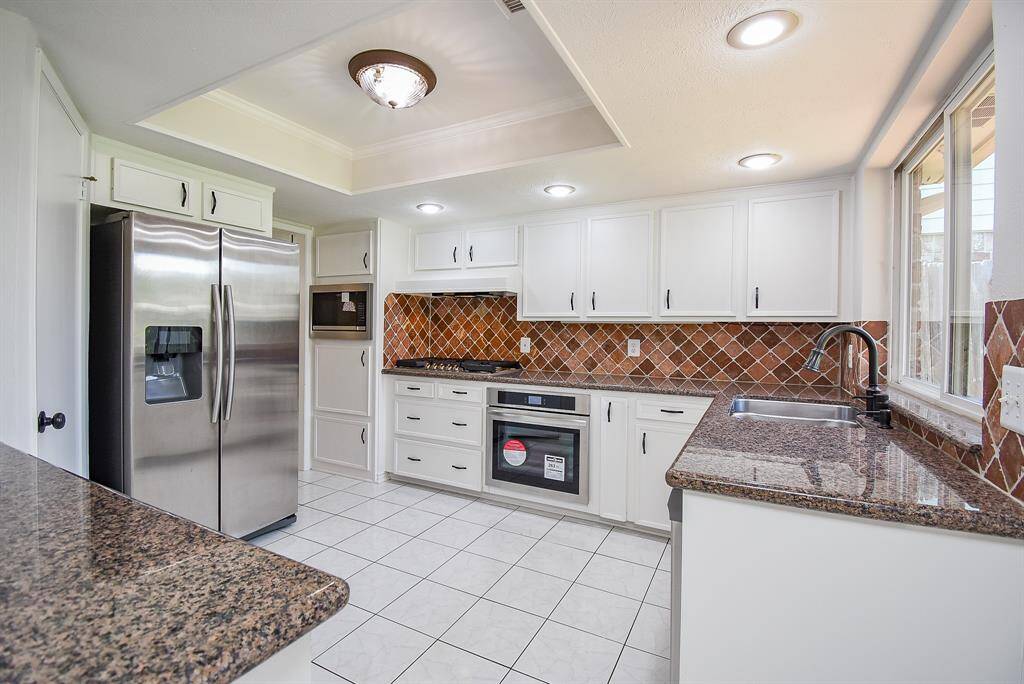 Kitchen has been updated with fresh paint and lighting and  new stainless steel appliances