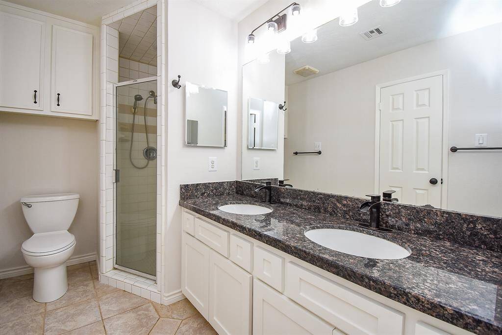 Primary bath with granite counter, double sinks and updated fixtures and lighting