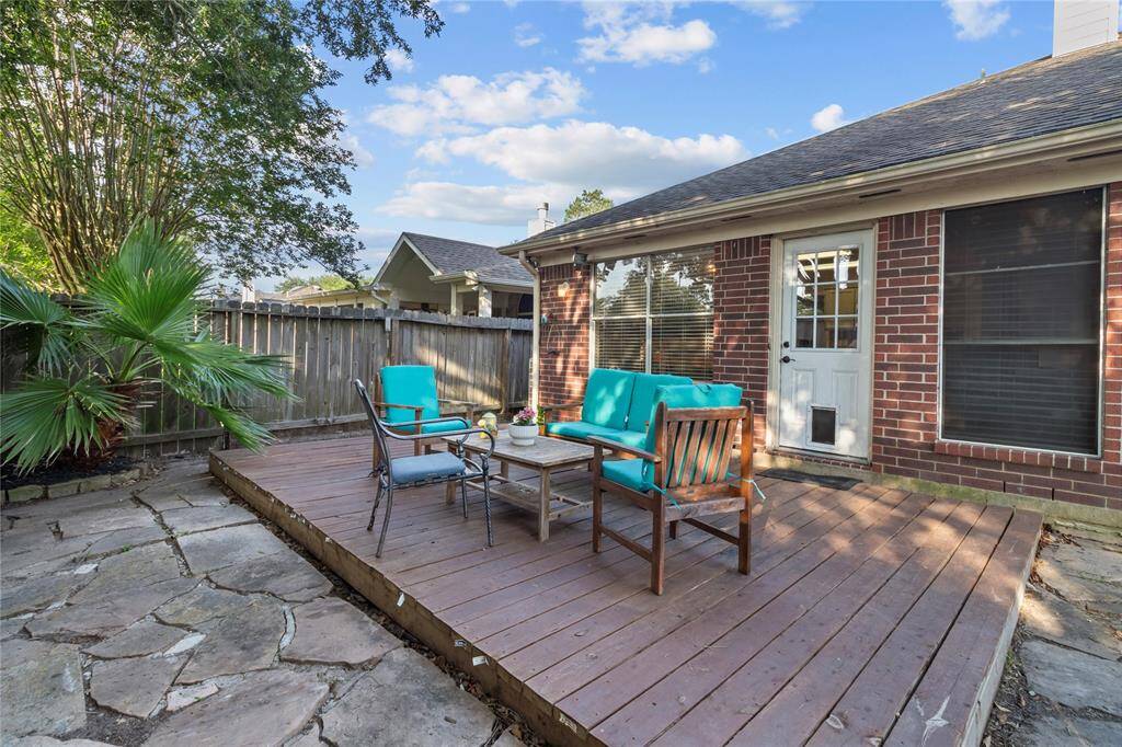 The wood deck creates a charming outdoor living space—perfect for relaxing, dining, or entertaining in the privacy of your own backyard.