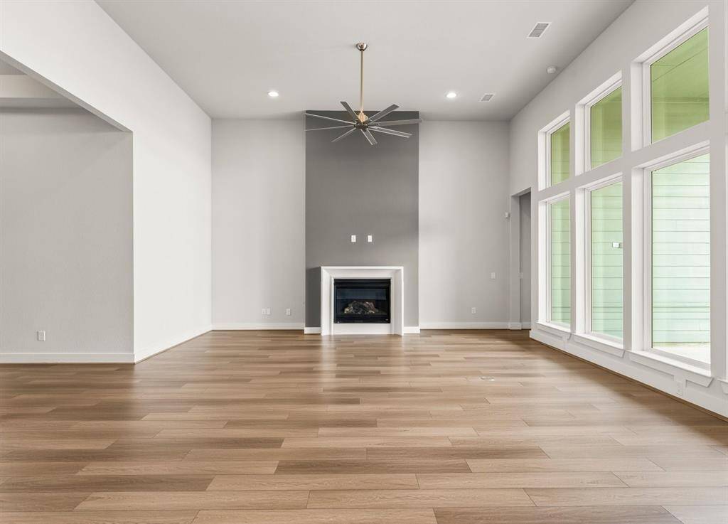 Great Room with 14ft. Ceiling, Tall Windows, Gas-Log Fireplace, and Fan.