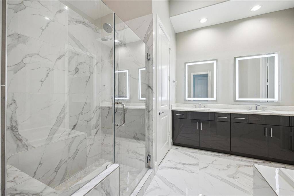 Beautiful primary bathroom withdouble vanity, separate tub and shower, and large closets