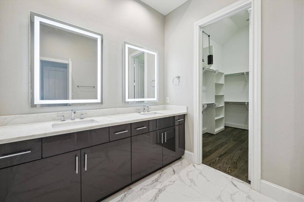 Beautiful primary bathroom withdouble vanity, separate tub and shower, and large closets