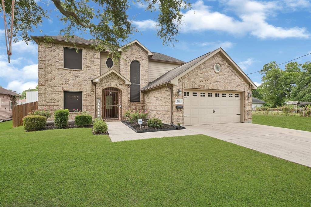 Brick exterior with arched entry, two-car garage, and beautifully manicured landscaping situated on a spacious lot with great curb appeal.