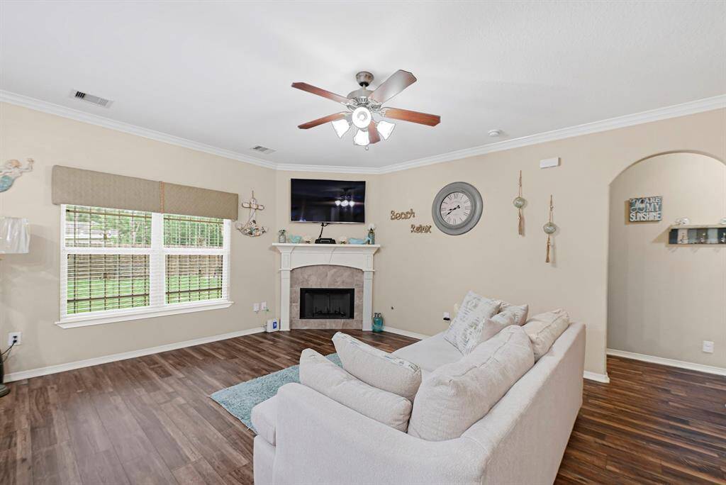 Bright and inviting living room with corner fireplace, and windows offering backyard views and plenty of natural light.