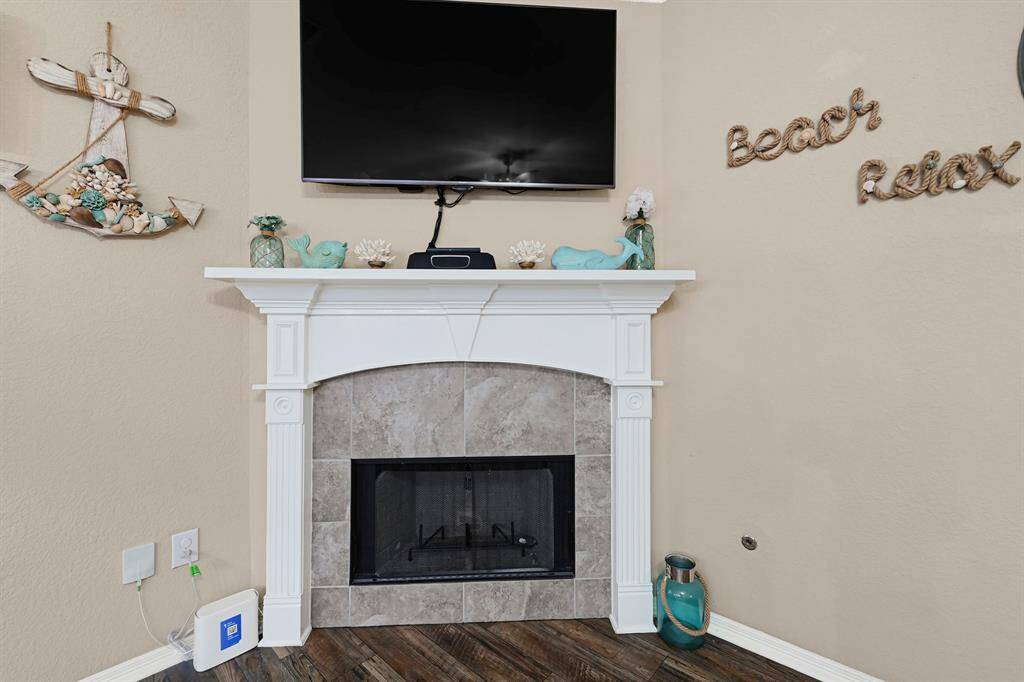 Cozy corner fireplace with tile surround and classic white mantel—adds warmth and charm to the main living area, perfect for relaxing evenings.
