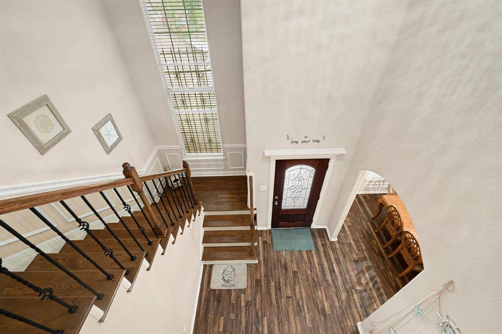 Stunning view from the upstairs landing overlooking the entry with high ceilings, and natural light from oversized windows.
