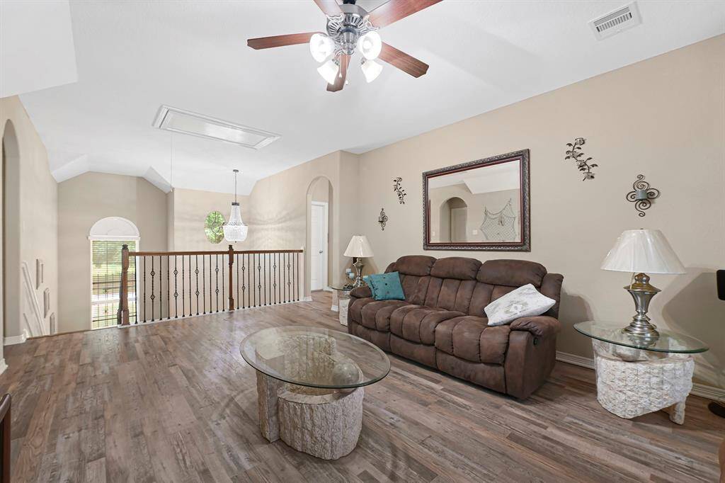 Versatile second-floor game room or media space with high ceilings, and natural light overlooking the foyer —ideal for entertaining, relaxing, or movie nights.