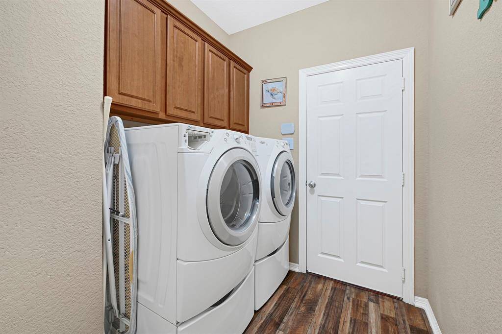 Indoor utility room with upper cabinet storage.