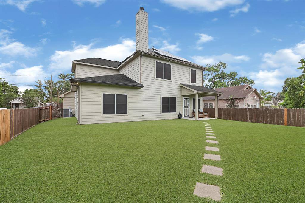 Expansive fenced backyard with covered patio and plenty of green space—perfect for entertaining, pets, or future outdoor projects.