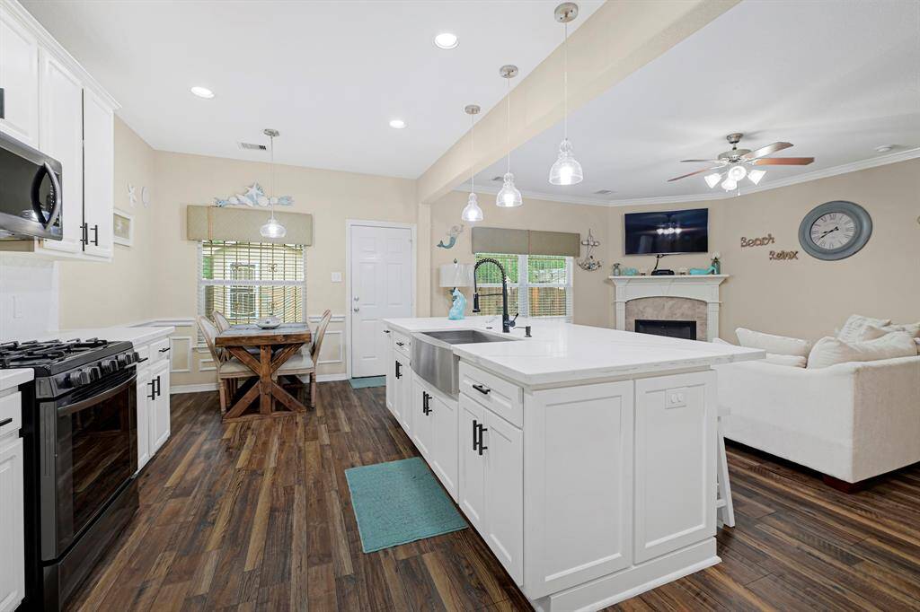 Open-concept kitchen flowing seamlessly into the cozy living area with fireplace.