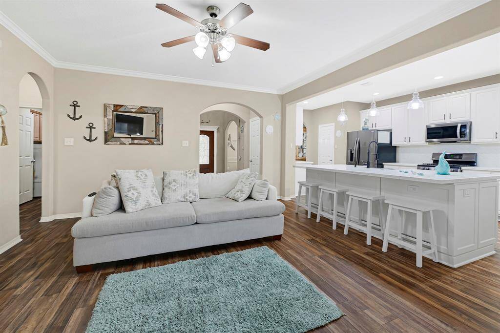 Cozy living room with direct sightlines to the kitchen, and oversized island with bar seating ideal for entertaining and everyday living.