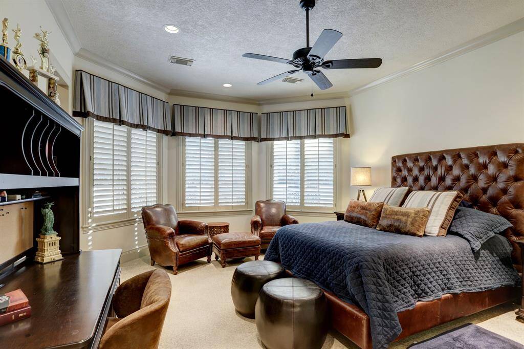 This spacious secondary bedroom features a charming bay window, plantation shutters, ample room for relaxation and privacy, an ensuite bath, and a generous walk-in closet.