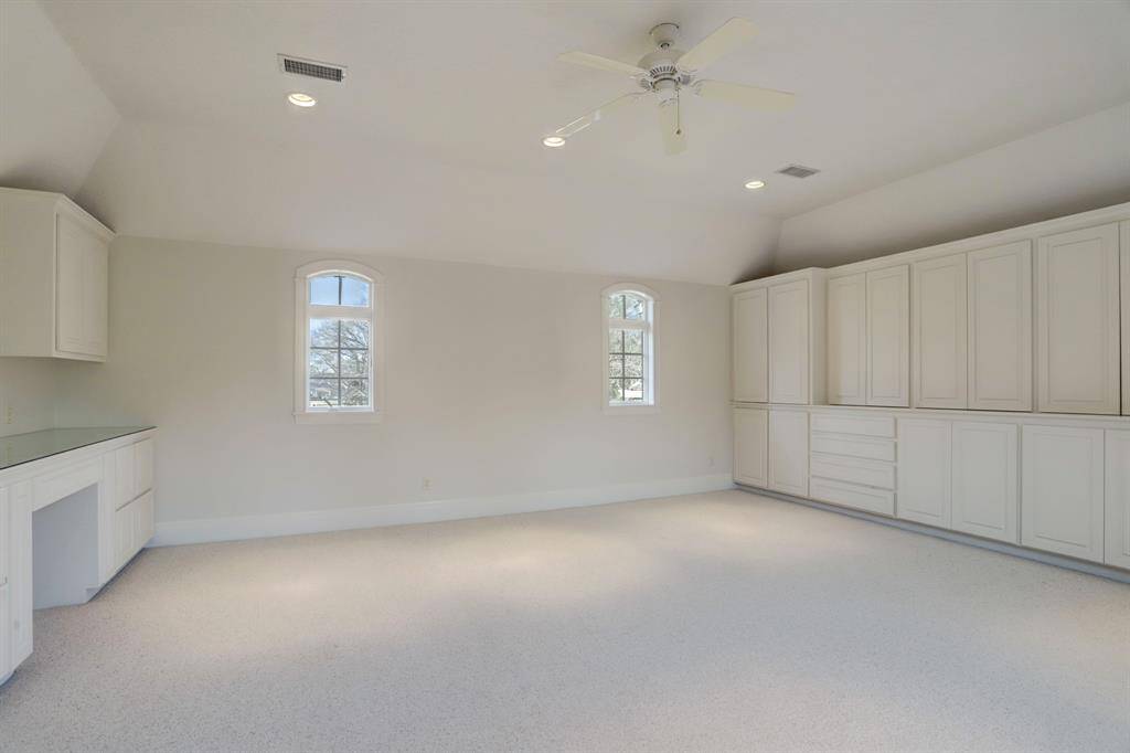 The 4-car garage features a dedicated workshop area, ample storage, and pristine epoxy floors, with convenient access via the motor court.