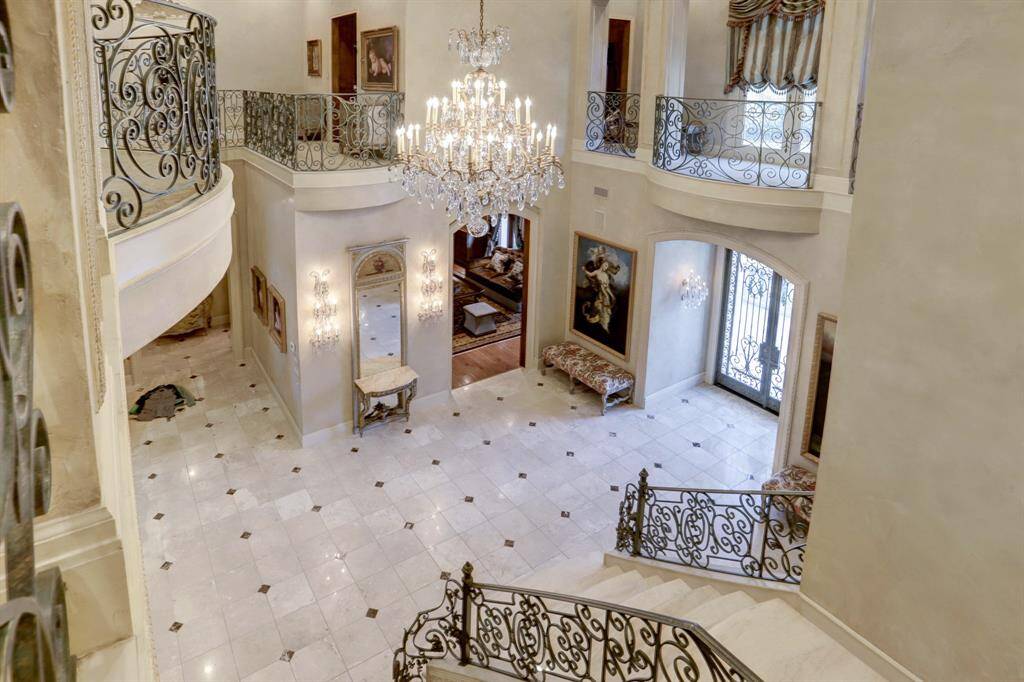 View from above foyer showcases the gleaming marble floors and 18th Century Venetian plaster technique on walls and trim and hand-crafted stair railing and balconies.