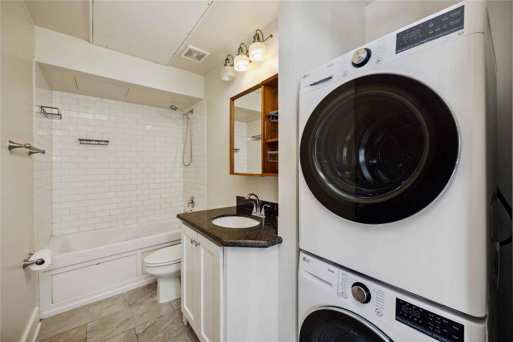 Conveniently tucked away in the bathroom you'll find a stackable washer and dryer that convey with the home.