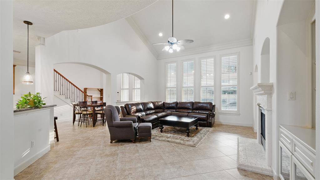 Gorgeous 2 story living room with stone cast fireplace and expansive windows. As with all the rooms, plantation shutters are on all of the windows.