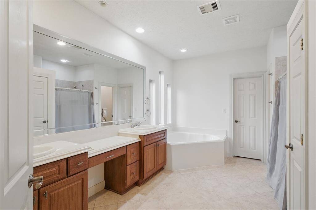 Large primary bathroom with double sinks, jetted tub and walk in shower.