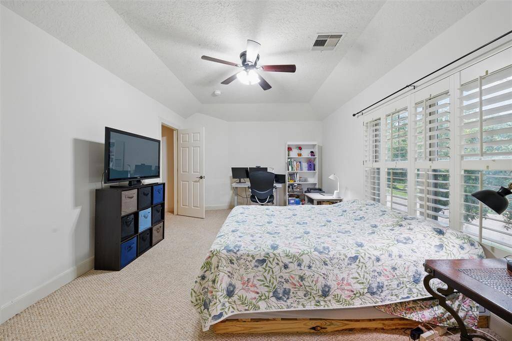 Another spacious upstairs bedroom on the front of the home with vaulted ceilings and en-suite bath.