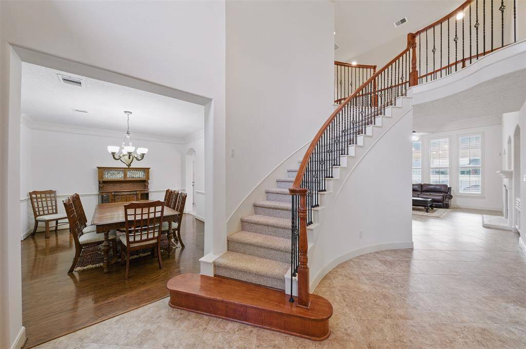 a grand staircase sets the tone at the entry, leading to the formal dining room, private study and opens up to the living room.