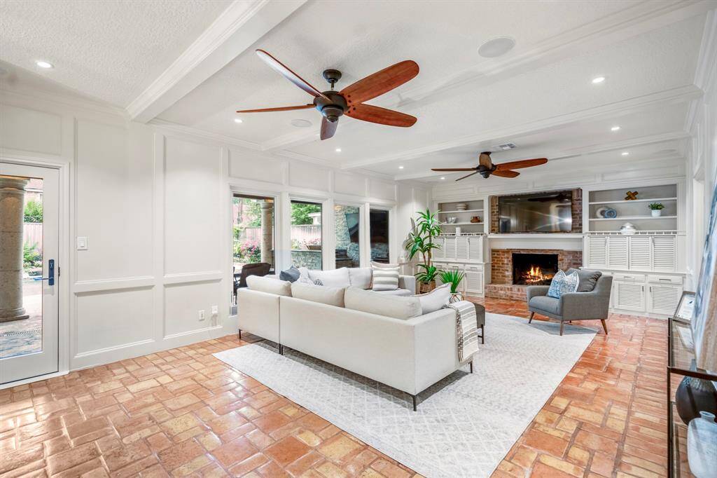 In the den you have a cozy brick surround on the fireplace, which offers built-ins for storage.