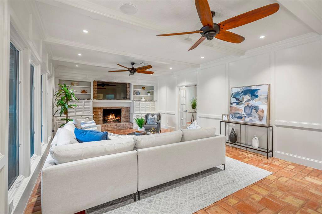 The open floorplan of the family room has beautiful paneling, new ceiling fans and great views of the backyard oasis.