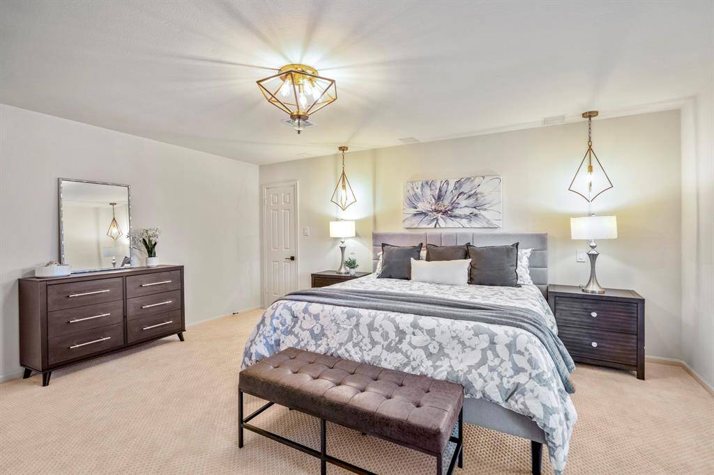 The primary bedroom has been updated with beautiful carpeting, incredible lighting and fresh paint.