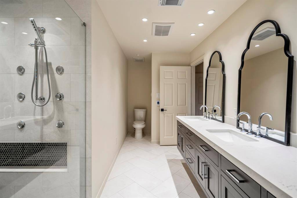 The shower offers several shower flows, dual sinks, updated lighting and beautiful quartz countertops.