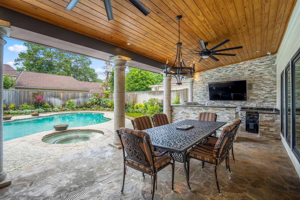 Enjoy this amazing outdoor kitchen with beautiful wood beamed ceiling, complete outdoor kitchen featuring propane/gas grill, gas cooktop, sink and refrigerator.