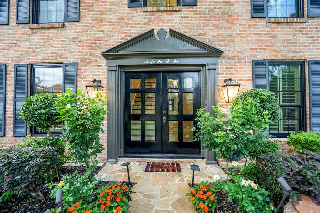 The custom double front metal door was upgraded and offers a peek into a gorgeous interior. Coach outdoor lighting flank the impressive front door.