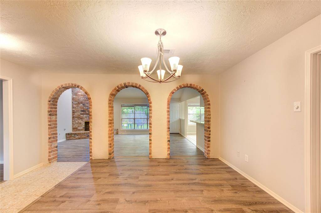 Character-rich brick archways provide a seamless and stylish passage from the foyer and formal dining room into the family room.
