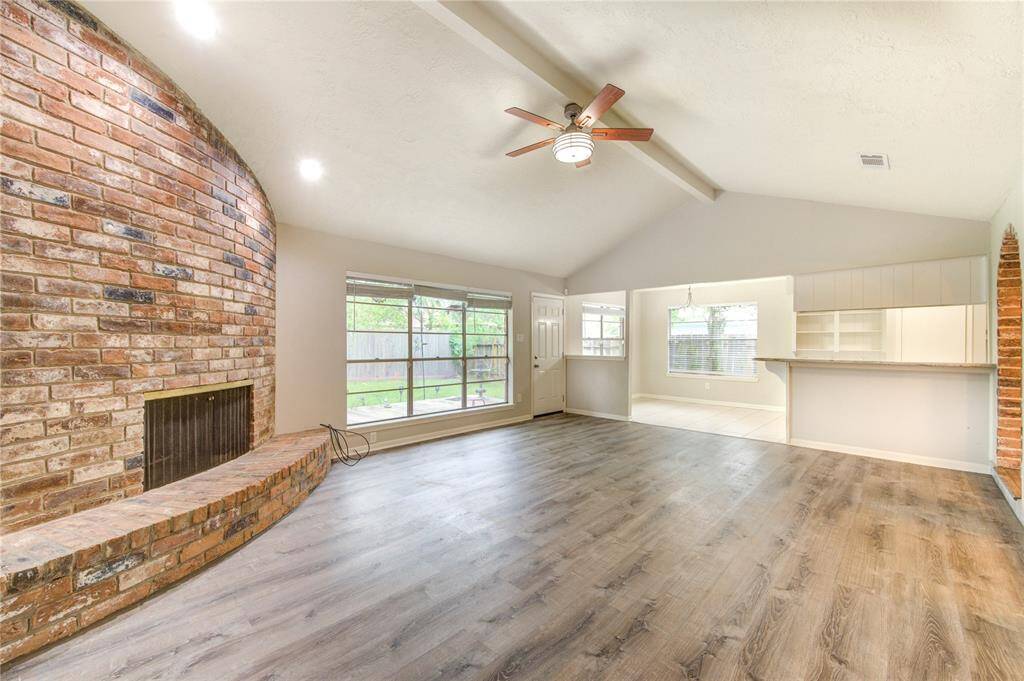 This rich brick fireplace exudes character and charm, seamlessly tying in with the brick-trimmed archways for a cohesive and inviting look.