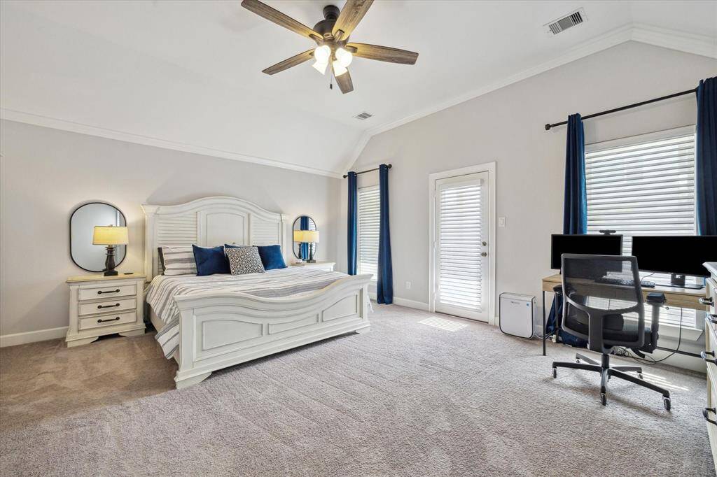 Oversized primary bedroom (18x15) on second floor has high coffered ceiling, ceiling fan,4 1/2 inch crown molding plus additional space for home office workspace. Door leads to covered second floor balcony.
