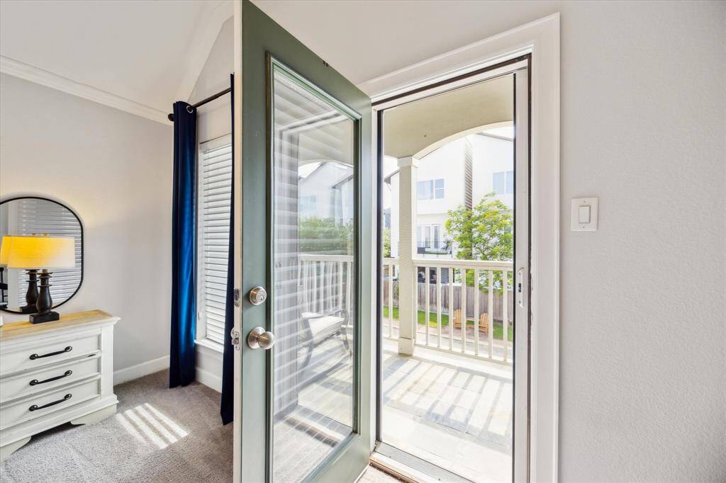 Bedroom has door that leads to a covered balcony.