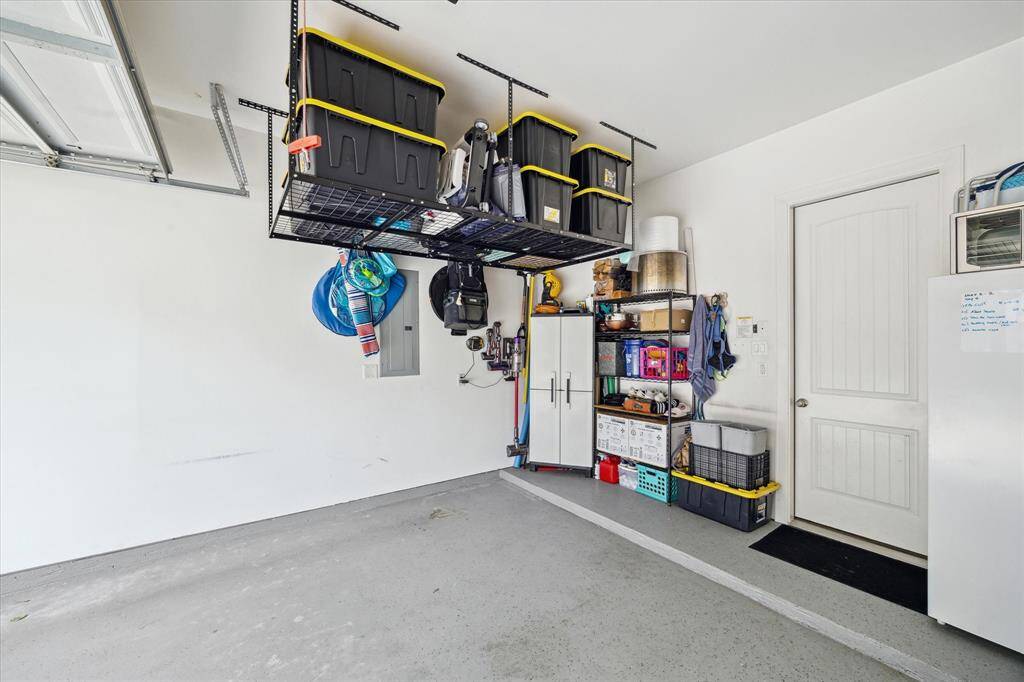Hanging storage in garage allows for additional off season storage! Door leads into kitchen.