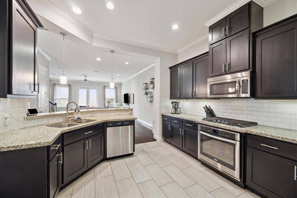 The kitchen (13x11) is well designed, clean, and professional. Subway tiled back splash, gas cooktop and stainless appliances. Breakfast bar with pendant lighting, amazing storage and is open to dining and living areas. Under cabinet lighting.
