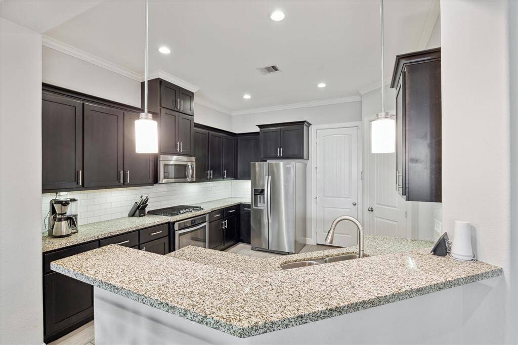 Opposite view of kitchen showing even more cabinets and storage. Door in center leads to 2 car attached garage. Just to the right of the door is a large walk-in pantry!