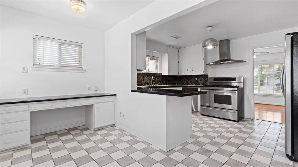 Clean and bright eat in kitchen with built-in desk.