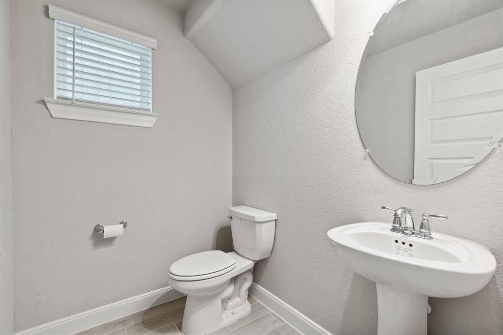 The half bathroom has a modern pedestal sink.