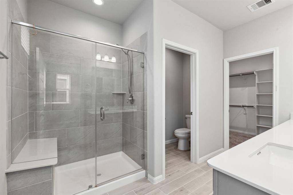 There is also a spacious walk-in shower with tile surround and sitting area.