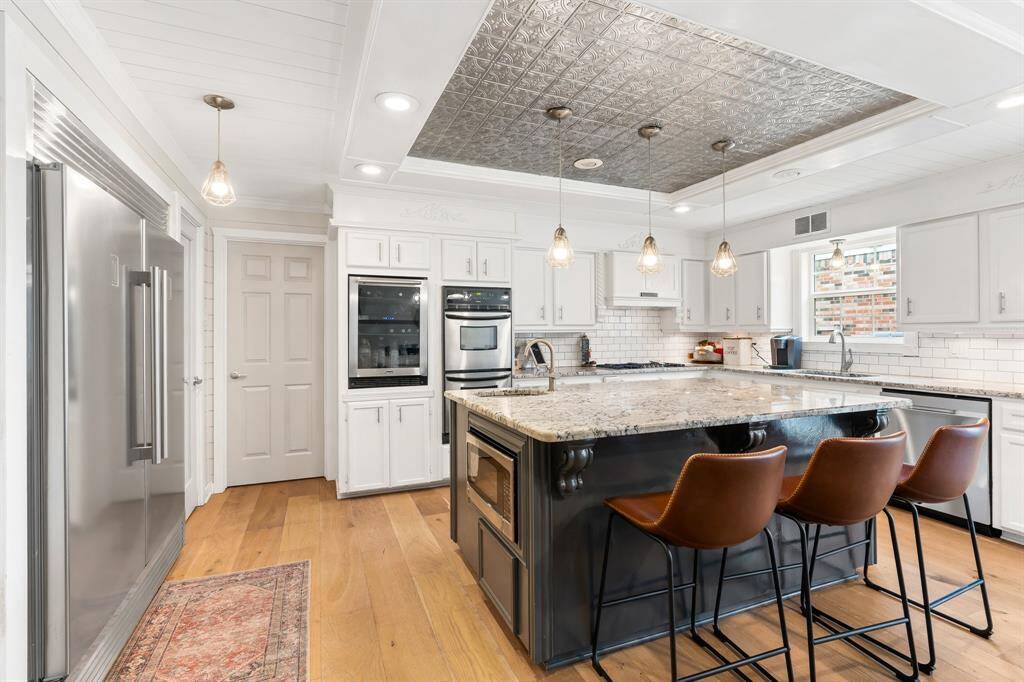 The room is accented by pendant lighting and a decorative ceiling, creating a modern and inviting atmosphere.