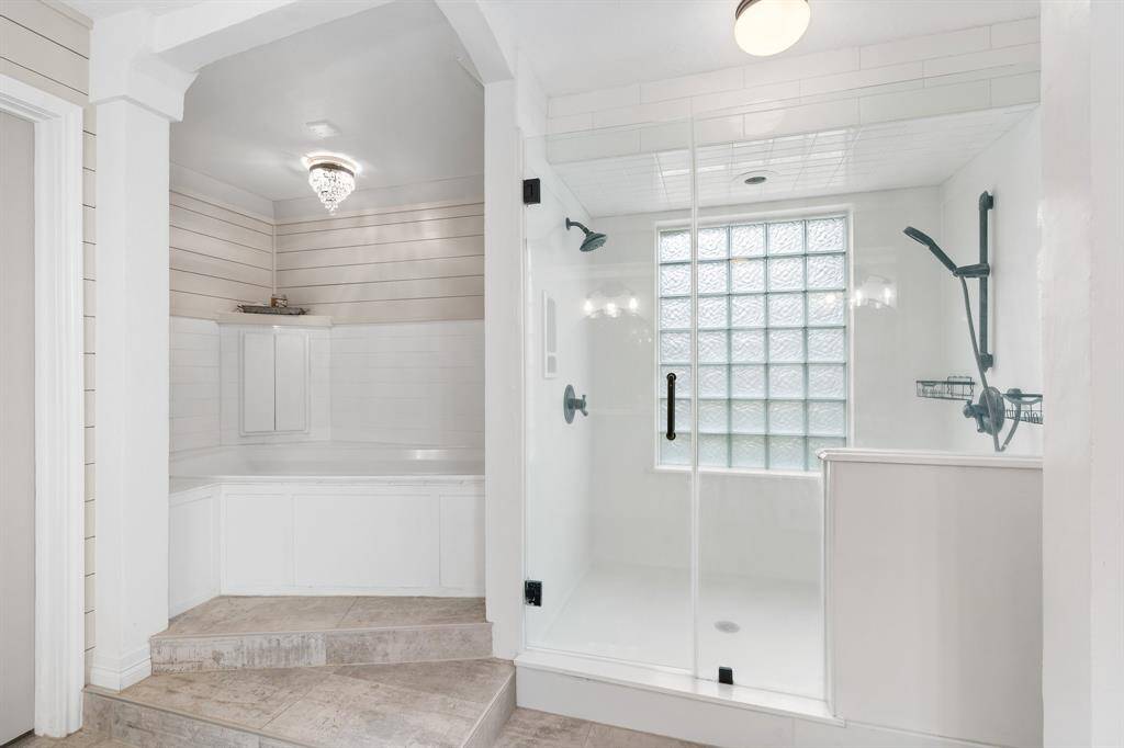 Luxurious primary bath featuring a spacious glass-enclosed shower and elegant tile details for a serene retreat.