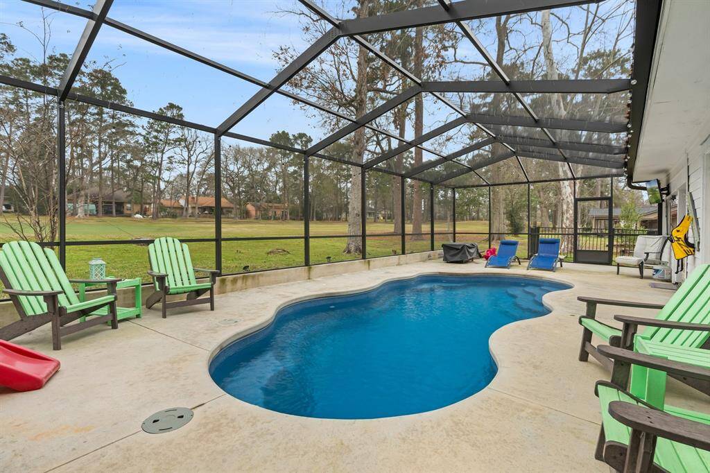 Screened-in backyard pool area with a smooth concrete deck.  The space provides a relaxing outdoor retreat.