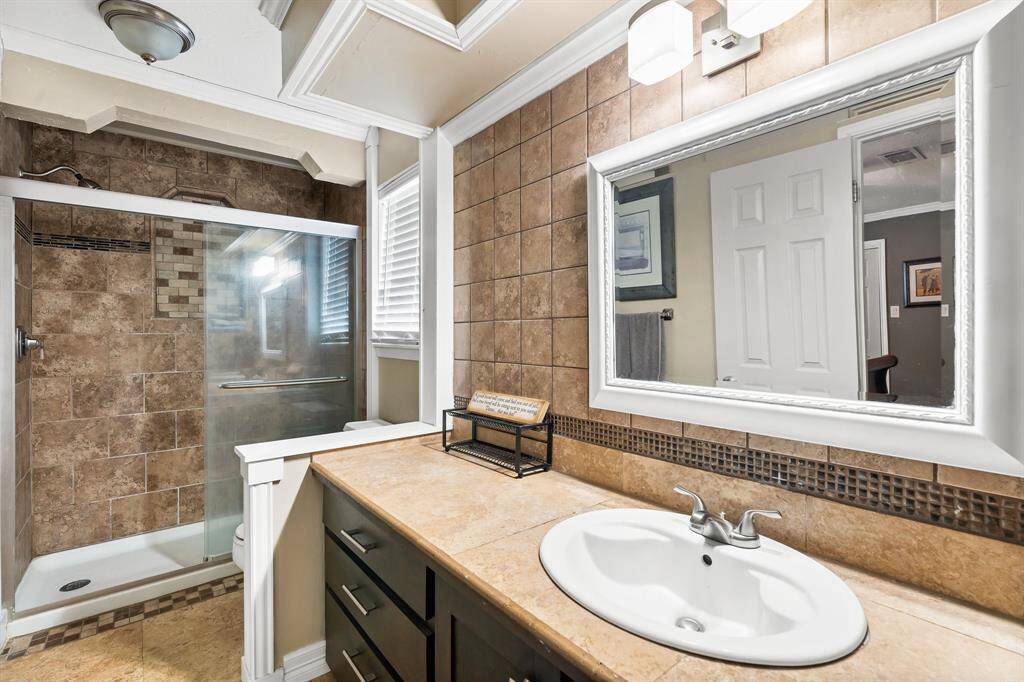 Elegant upstairs bathroom with a modern shower and stylish vanity.
